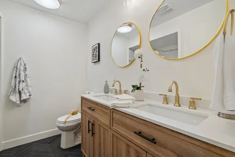 a bathroom with a granite countertop sink mirror and toilet