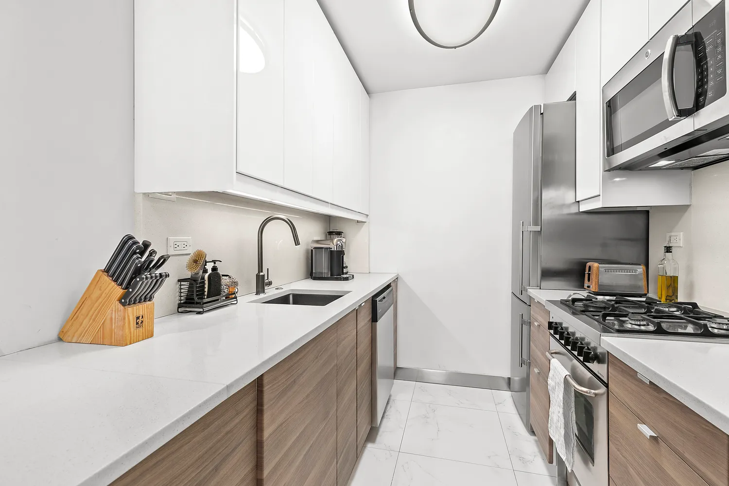 a kitchen with stainless steel appliances granite countertop a sink a stove and a refrigerator