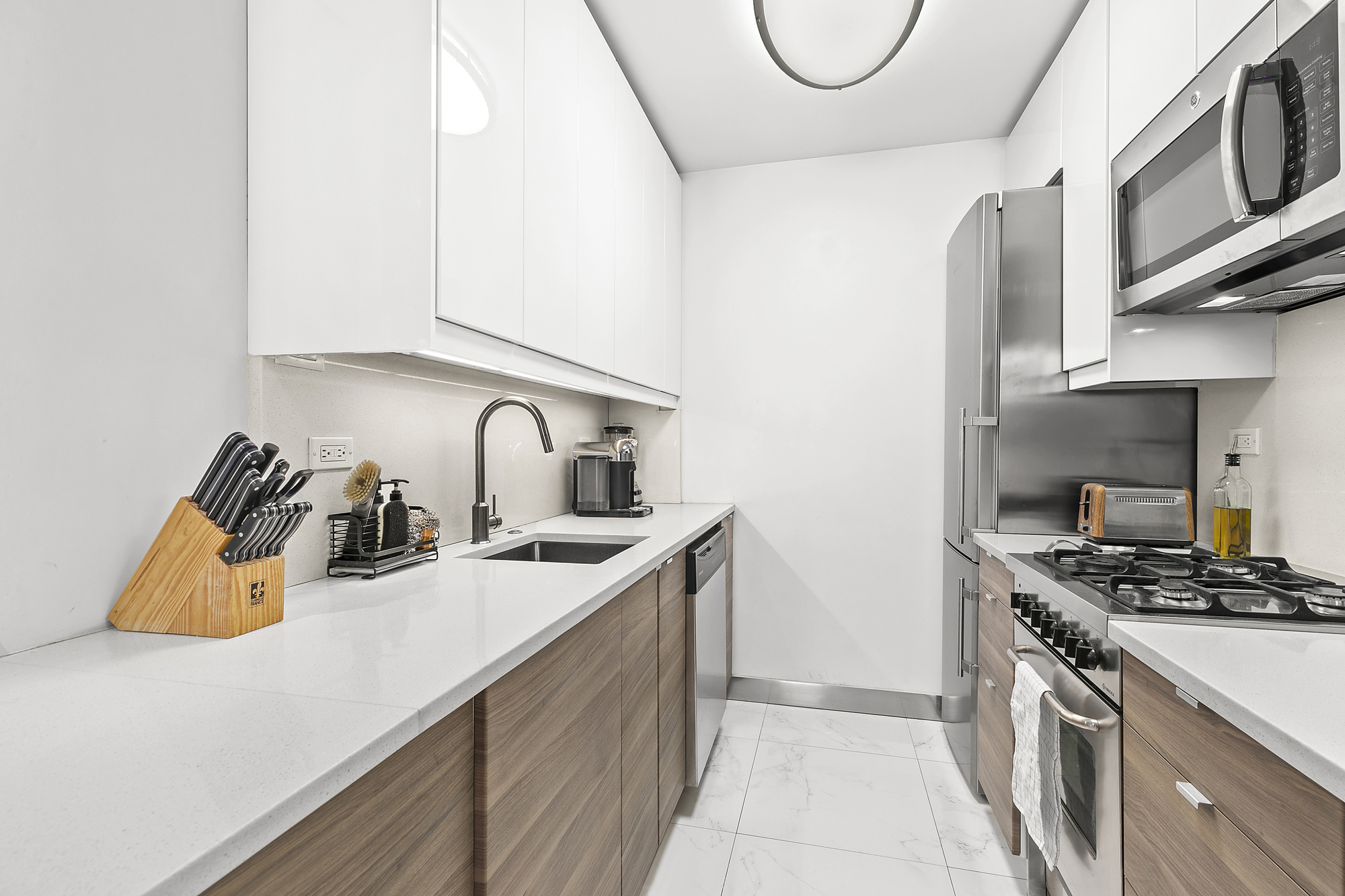 420 West 23rd Street, Unit 6B Manhattan, NY 10011 - Photo 3 of 11 a kitchen with stainless steel appliances granite countertop a sink a stove and a refrigerator