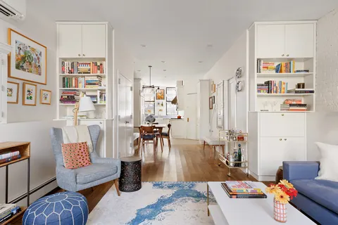 a view of a dining room with furniture a rug and wooden floor
