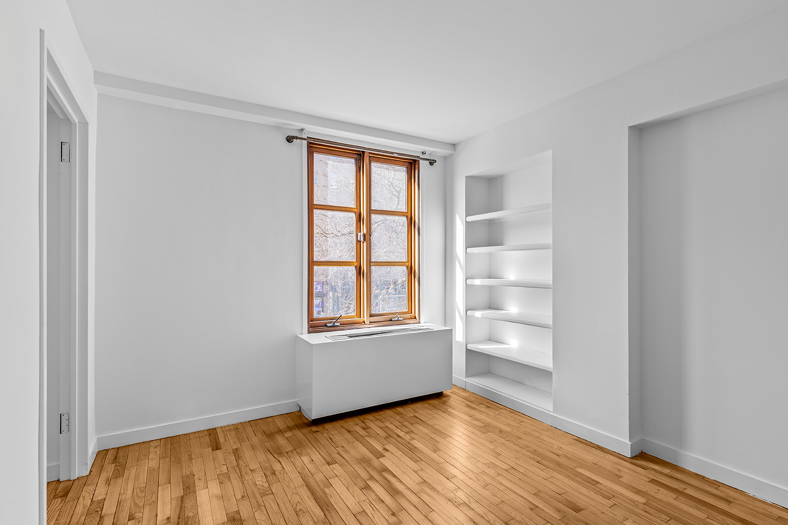 126 Waverly Place, Unit 2F Manhattan, NY 10011 - Photo 4 of 11 a view of an empty room with a window and wooden floor