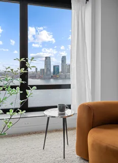 a living room with furniture and a floor to ceiling window