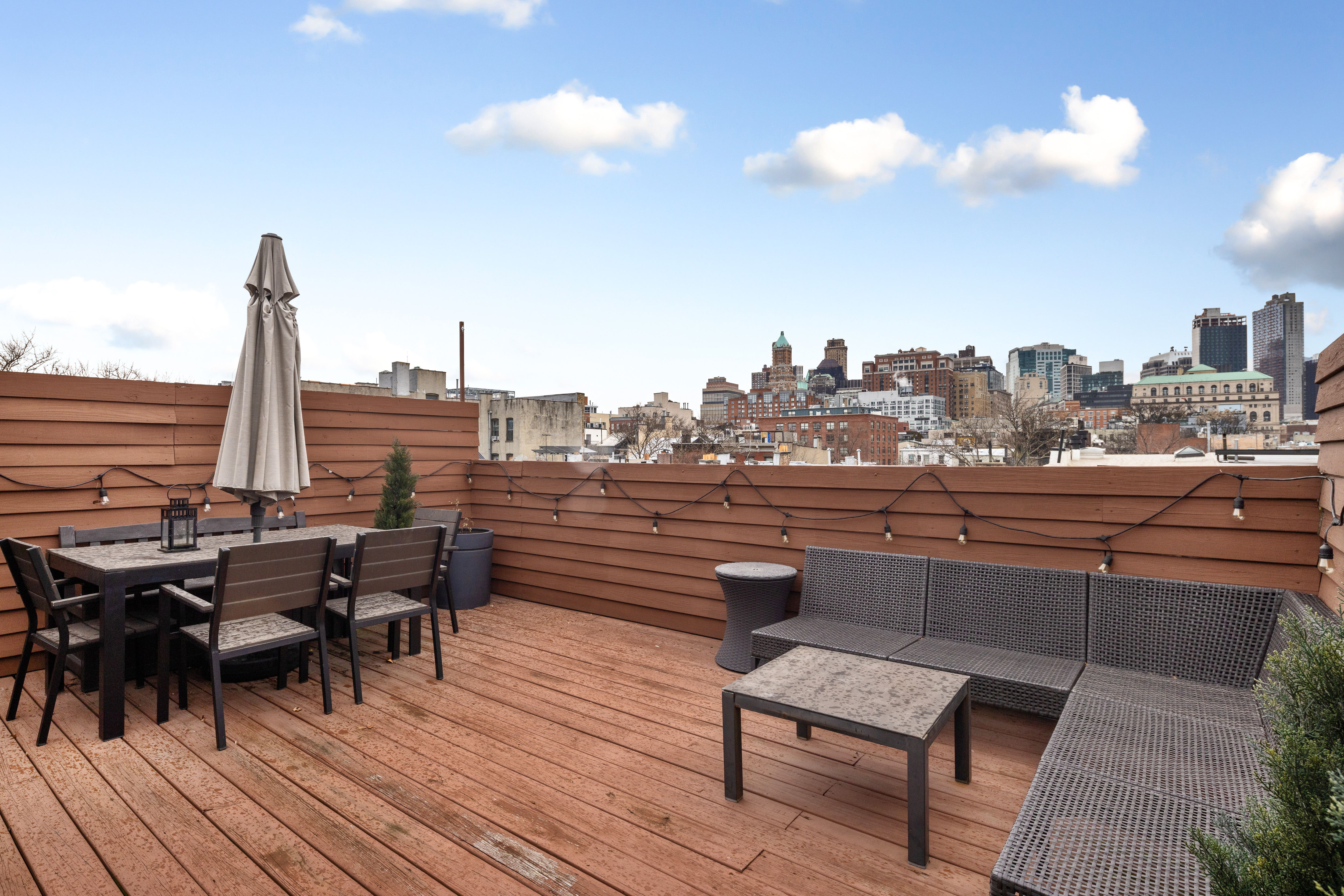 a roof deck with outdoor seating and city view