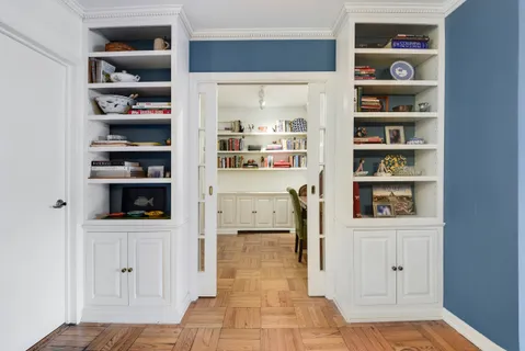 a hallway with cabinets and wooden floor