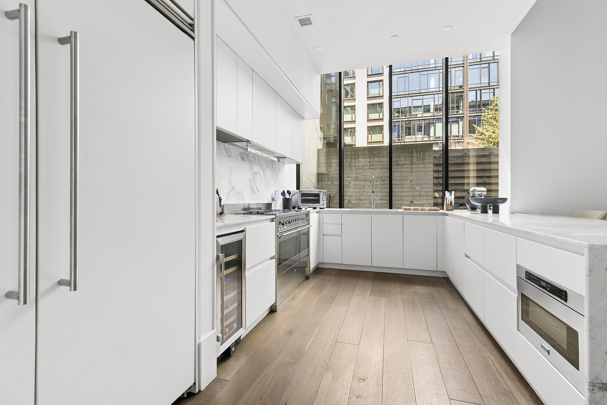 429 Kent Avenue, Unit TH8 Brooklyn, NY 11249 - Photo 4 of 24 a kitchen with a white cabinets and white appliances