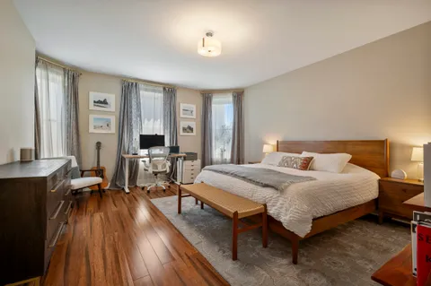 a bedroom with a bed and wooden floor