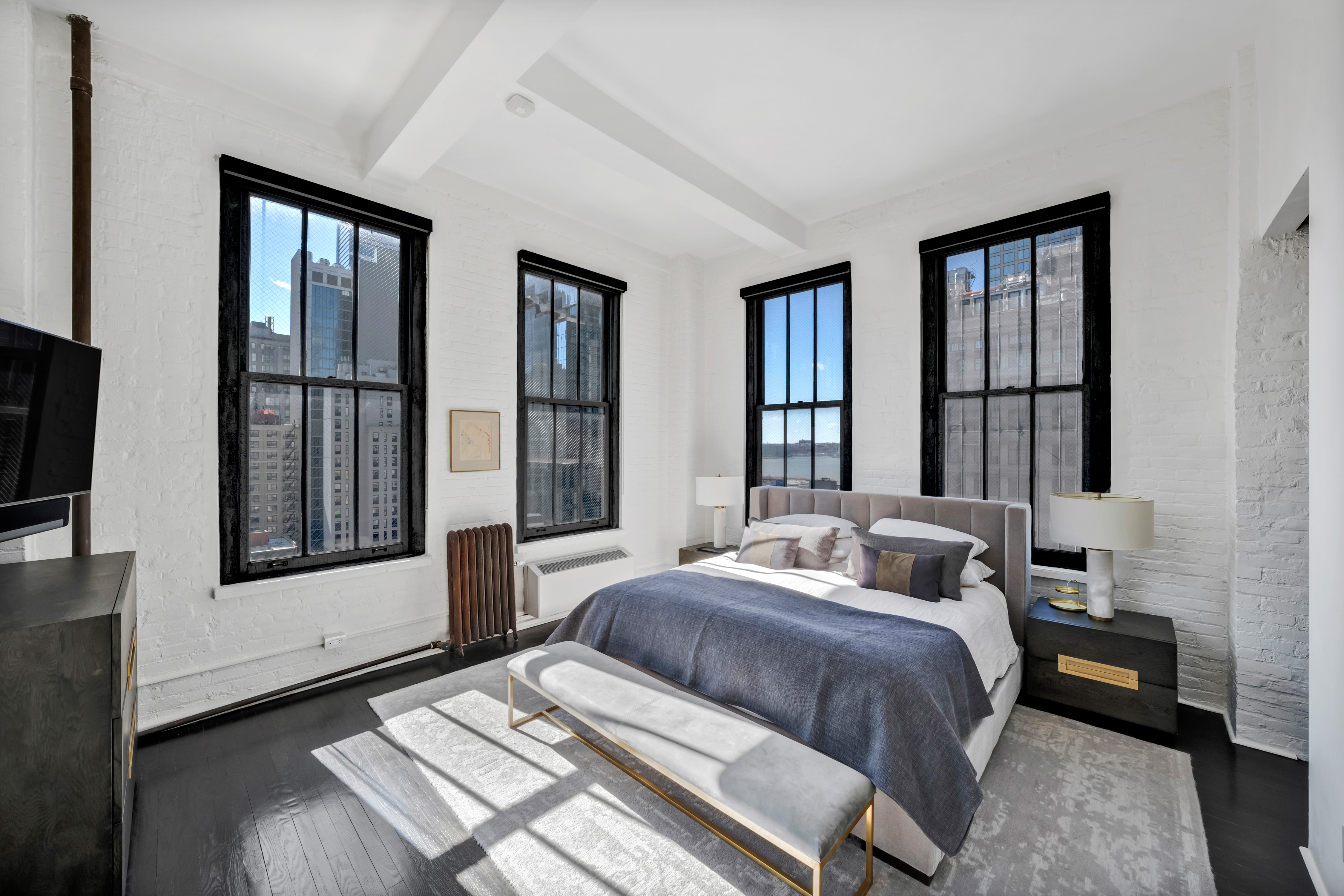 448 West 37th Street, Unit 11G/12G Manhattan, NY 10018 - Photo 11 of 17 a bedroom with two beds and a large window