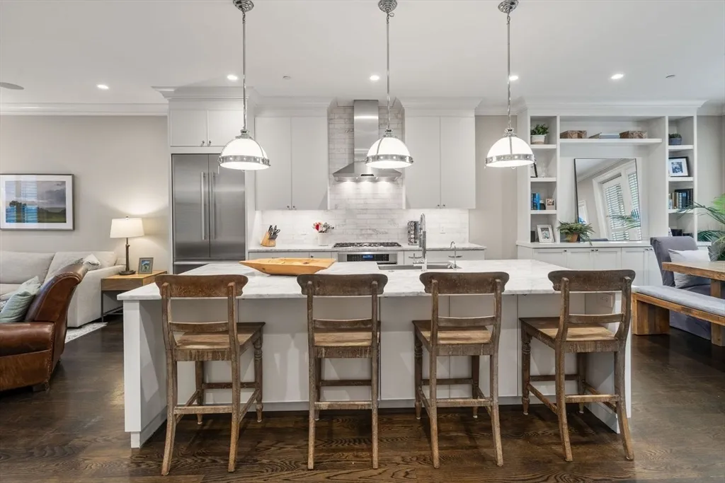 a dining area with furniture a large window and kitchen view
