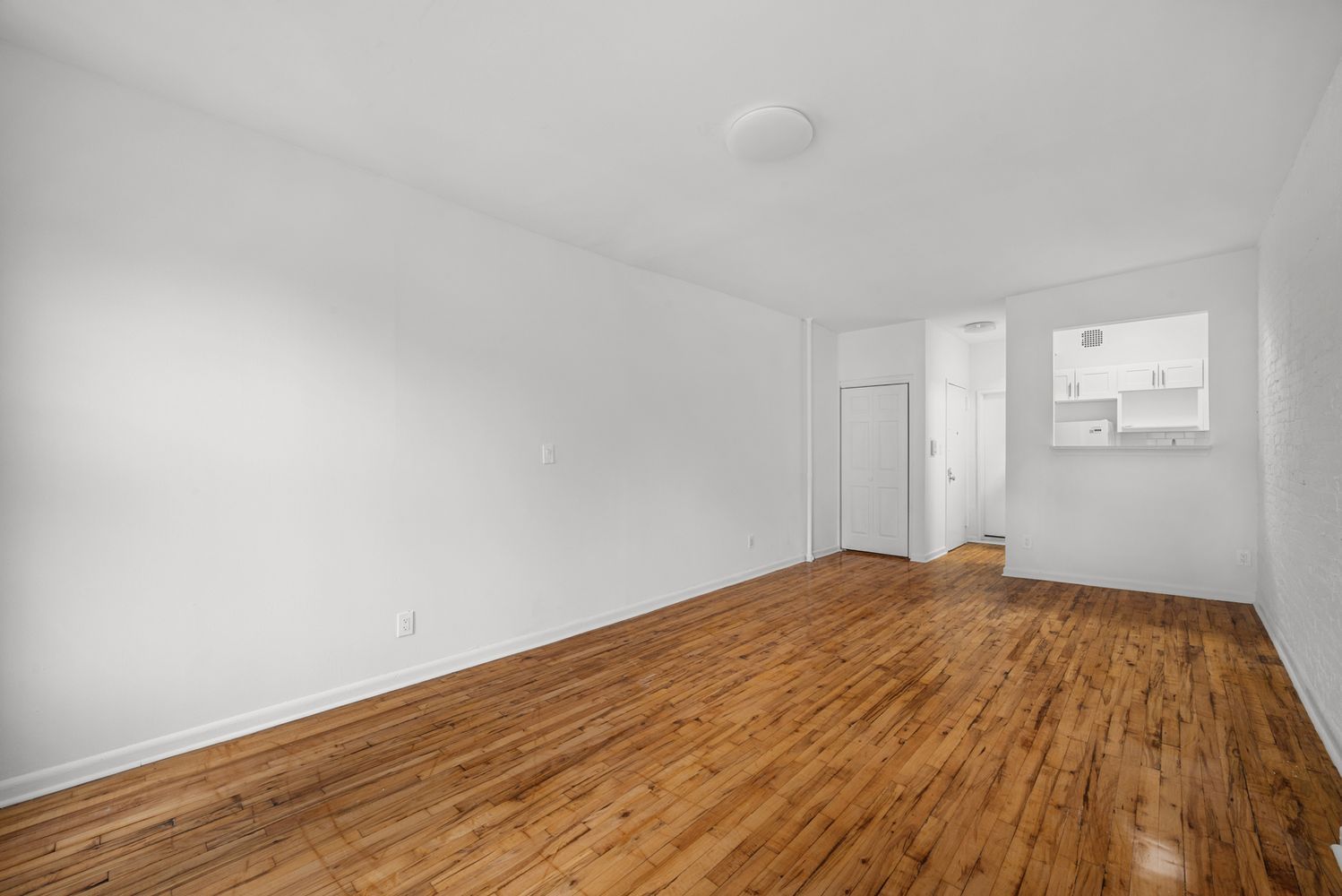 1105 1st Avenue, Unit 5 Manhattan, NY 10065 - Photo 2 of 5 a view of empty room with wooden floor and fan