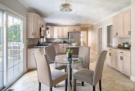 a kitchen with stainless steel appliances granite countertop a stove a refrigerator a kitchen island a table and chairs