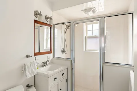 a bathroom with a sink mirror and a shower