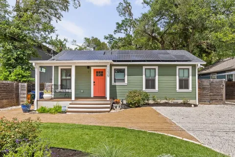 a front view of a house with a garden and yard
