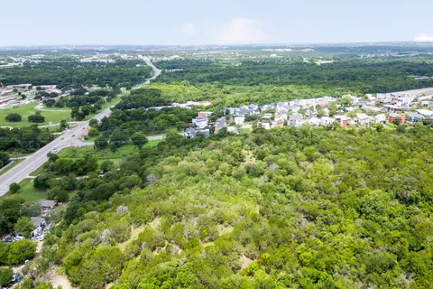 an aerial view of lake and residential houses with outdoor space