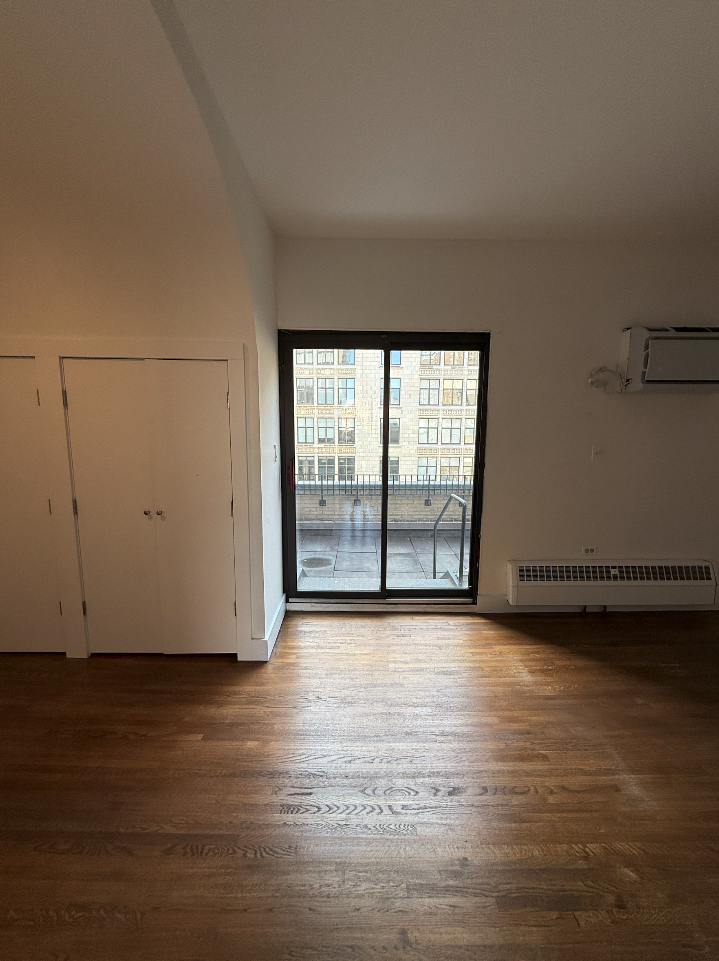 455 Park Avenue South, Unit PH1 Manhattan, NY 10016 - Photo 8 of 17 a view of an empty room with wooden floor and a window