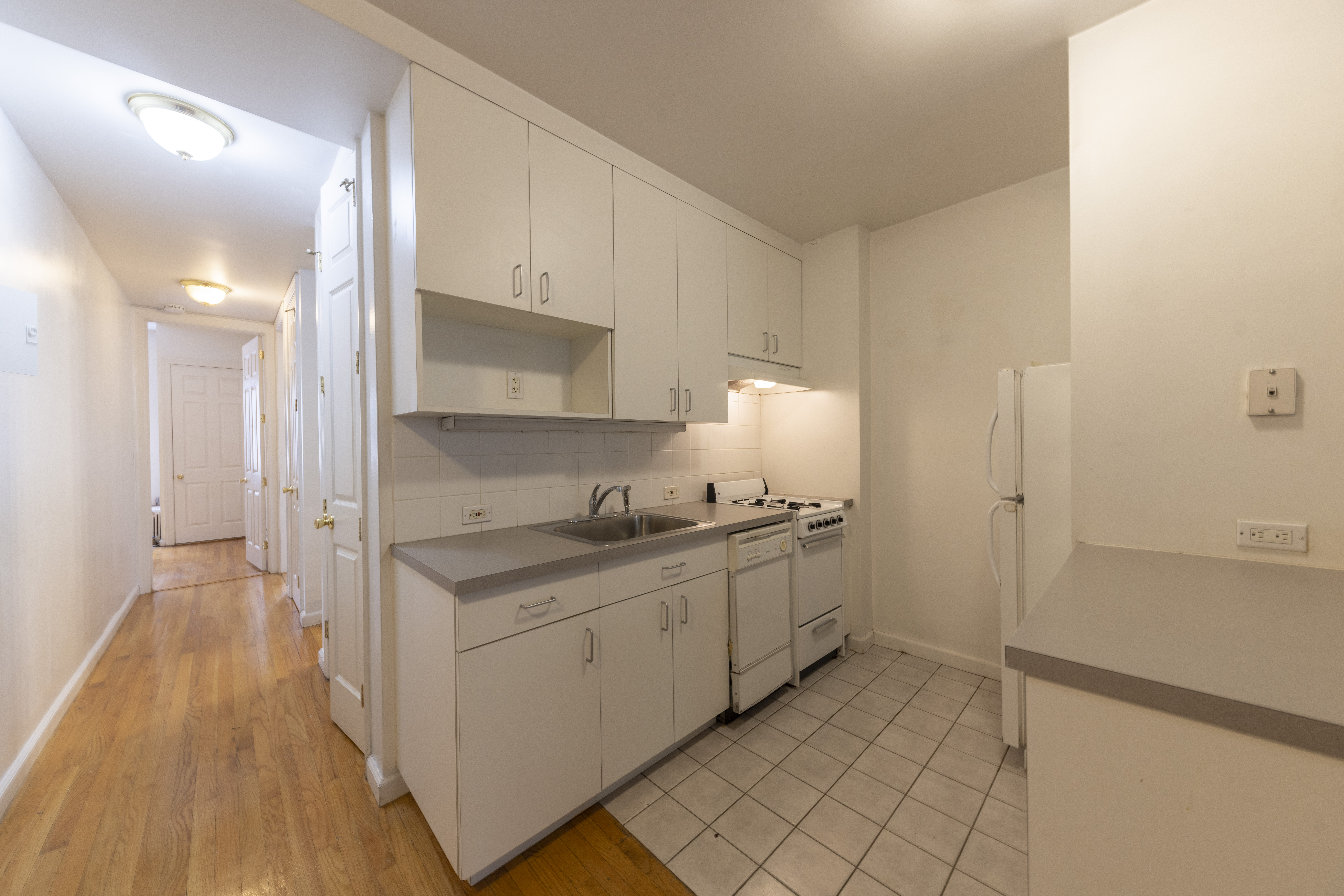 1384 Lexington Avenue, Unit 2 Manhattan, NY 10128 - Photo 4 of 11 a kitchen with stainless steel appliances granite countertop a stove a sink and a refrigerator