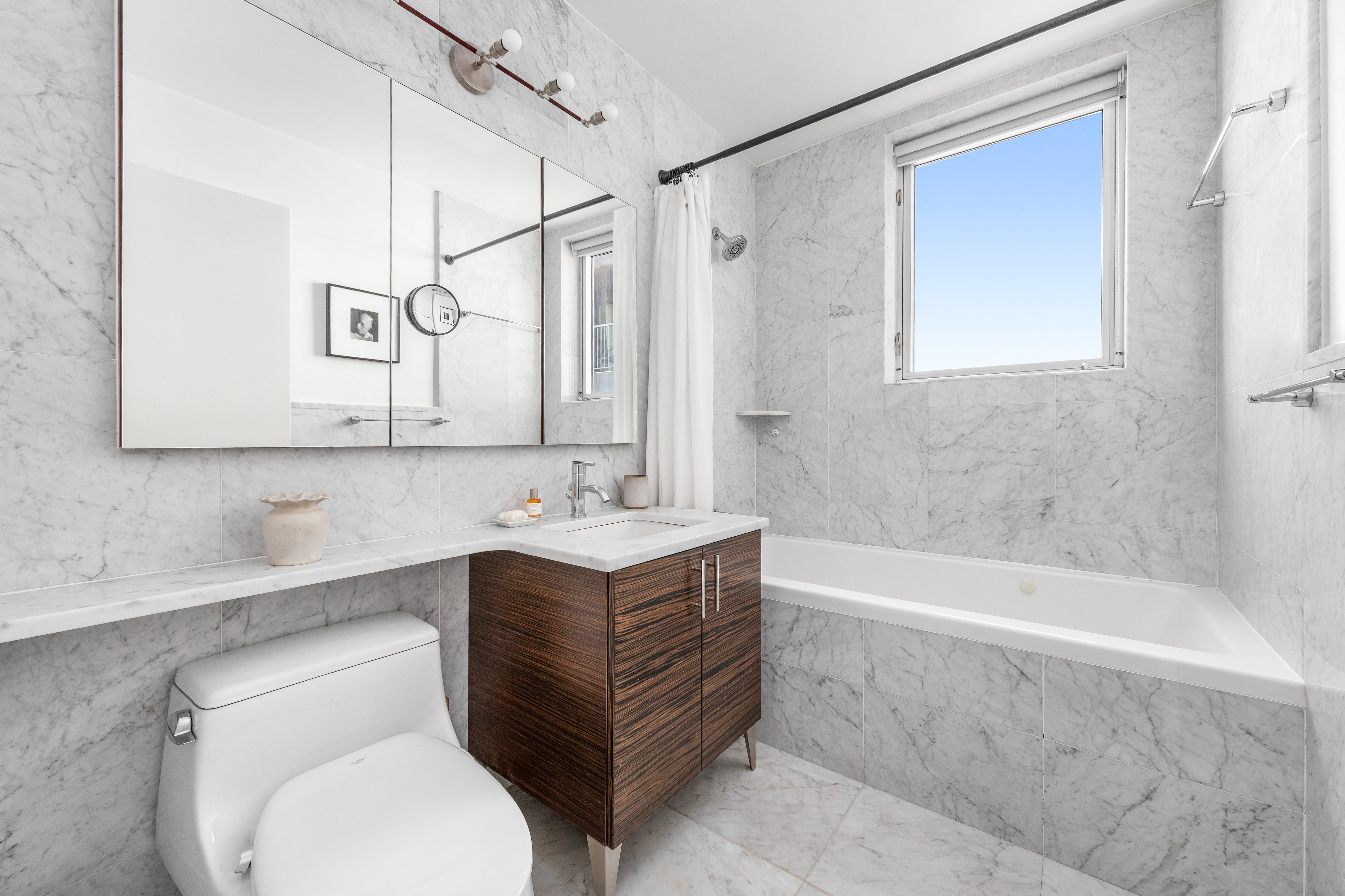 11-24 31st Avenue, Unit 5A Queens, NY 11106 - Photo 9 of 11 a bathroom with a sink a toilet and bathtub