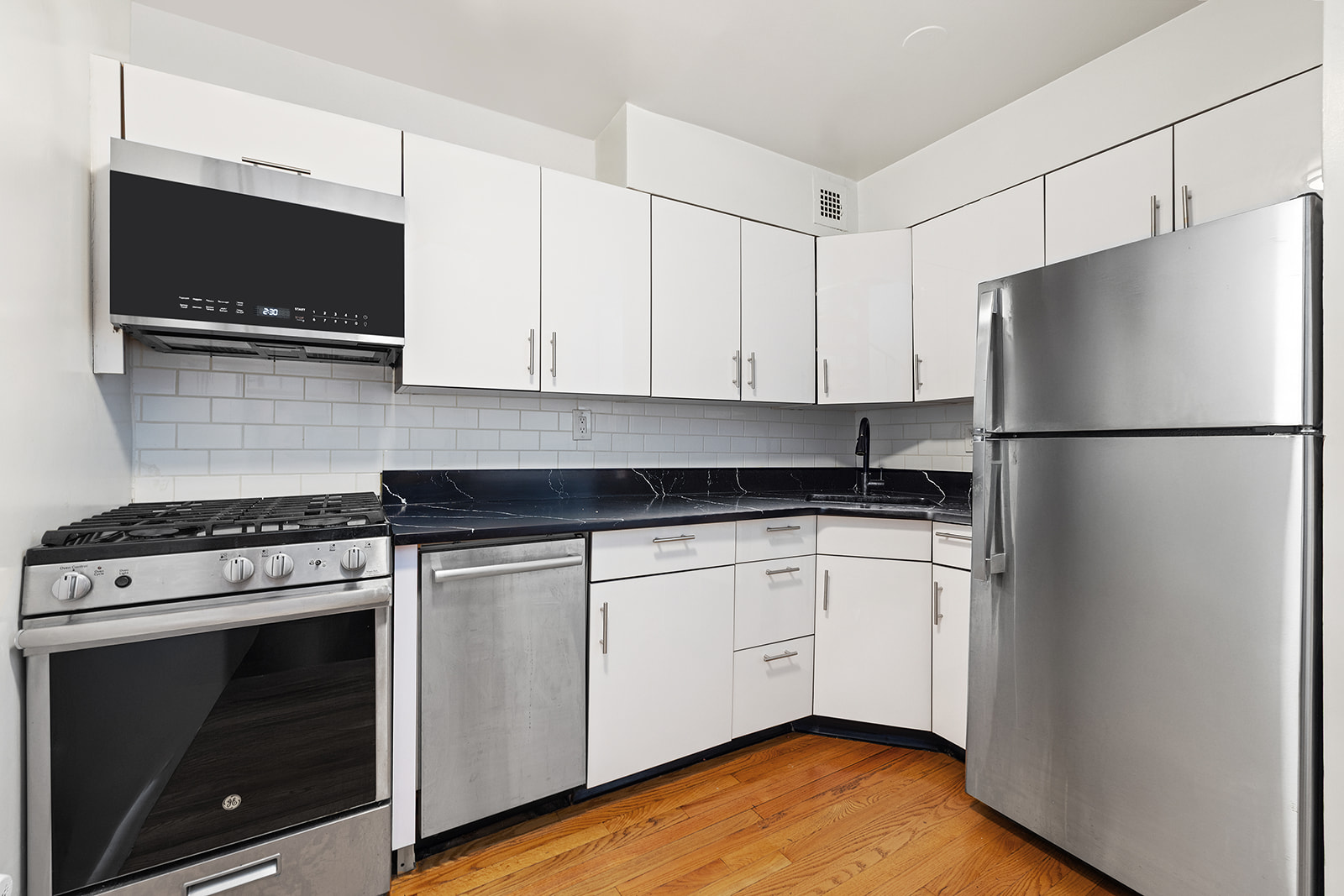 211 Thompson Street, Unit LJ Manhattan, NY 10012 - Photo 3 of 7 a kitchen with a stove microwave and refrigerator