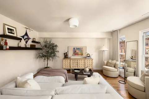a living room with furniture and a painting on the wall