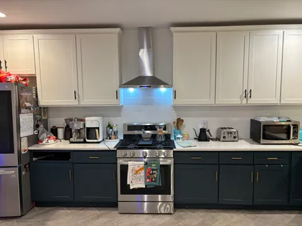 a kitchen with stainless steel appliances granite countertop a stove a sink and a white cabinets