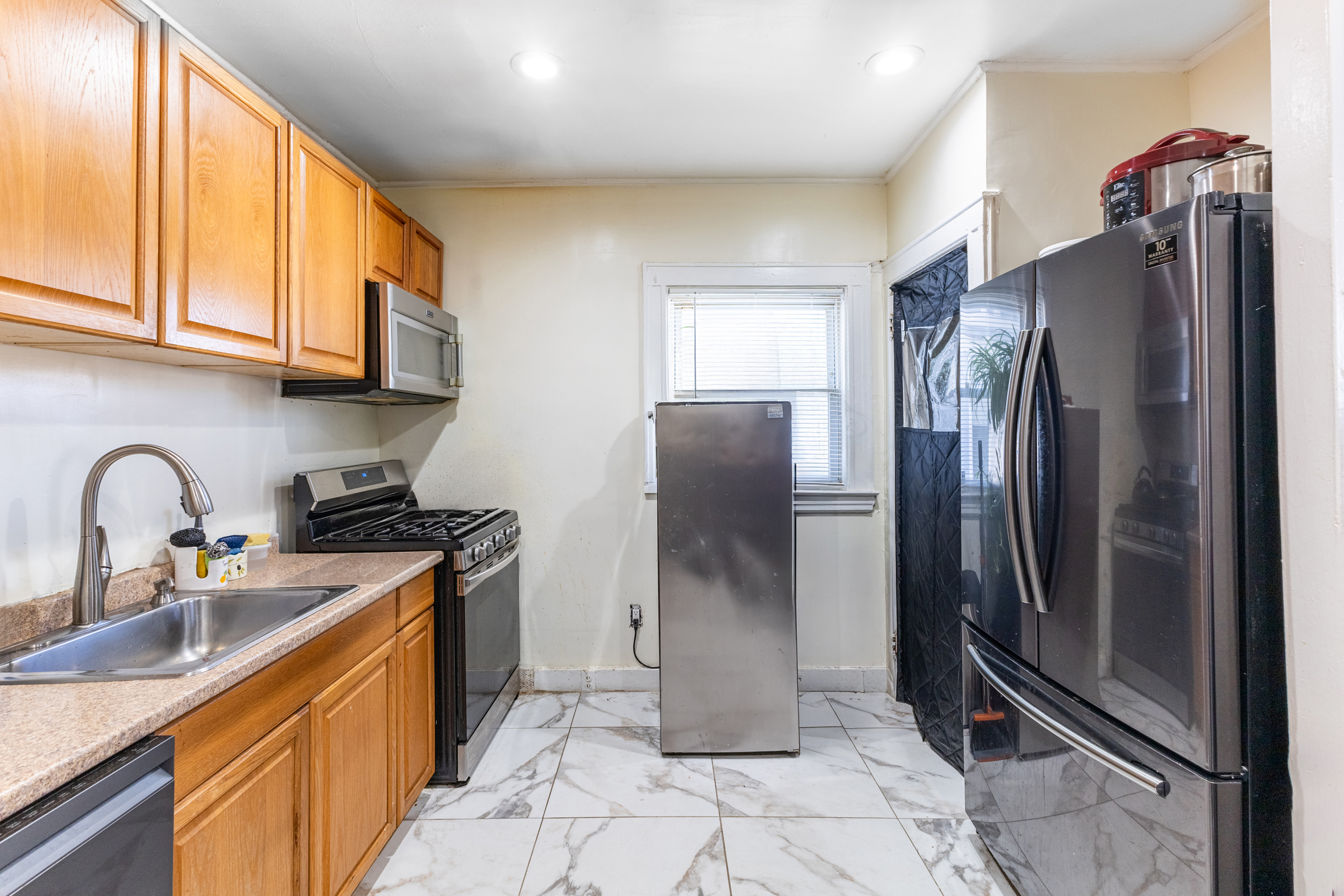 961 East 32nd Street Brooklyn, NY 11210 - Photo 15 of 24 a kitchen with stainless steel appliances granite countertop a refrigerator and a sink