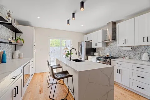 a kitchen with white cabinets and stainless steel appliances