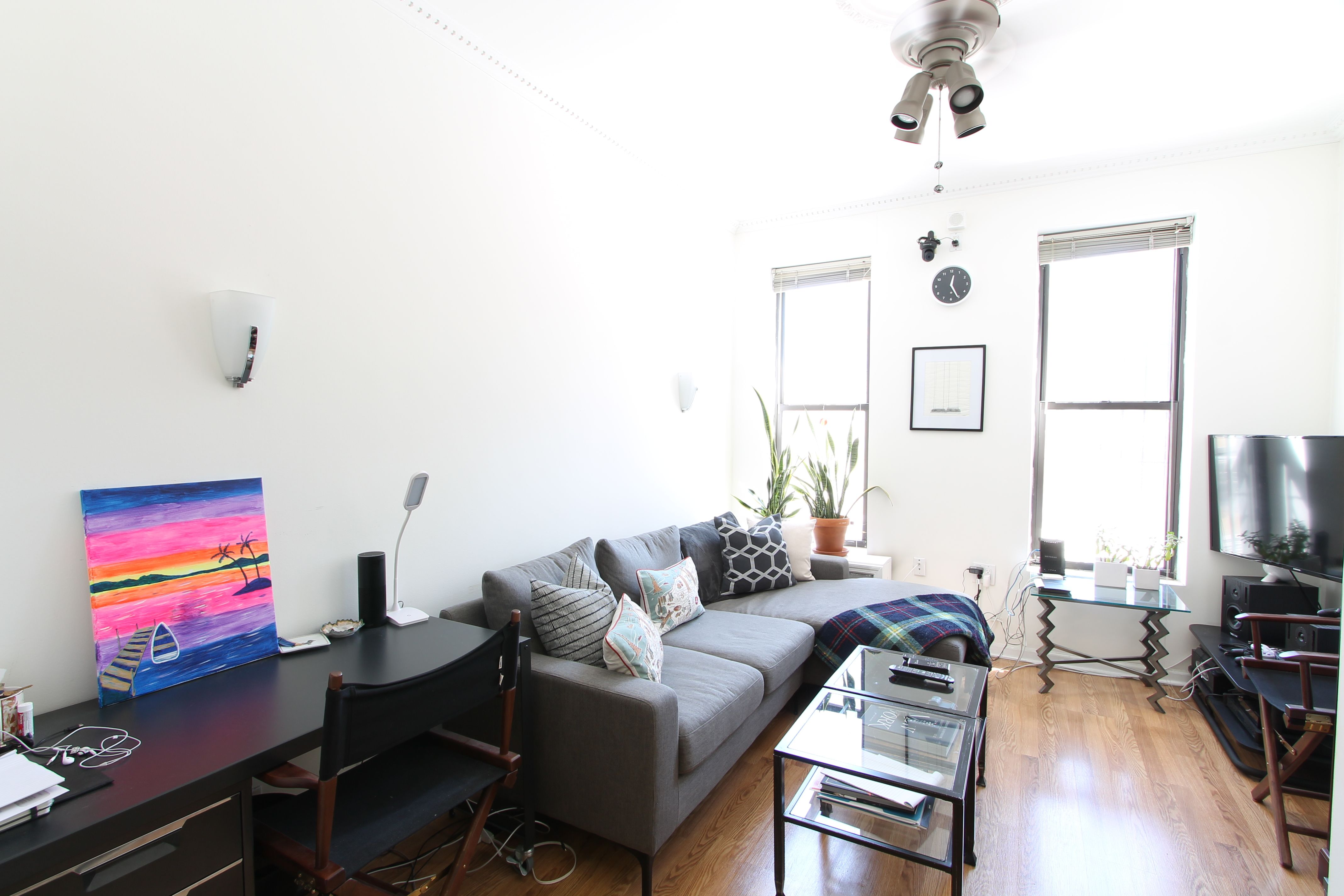 a living room with furniture a flat screen tv and a window