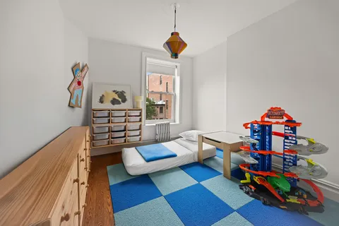 a living room with baby crib furniture and a window