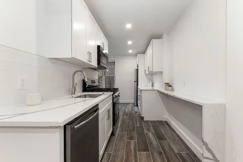 a kitchen with a sink a refrigerator and cabinets