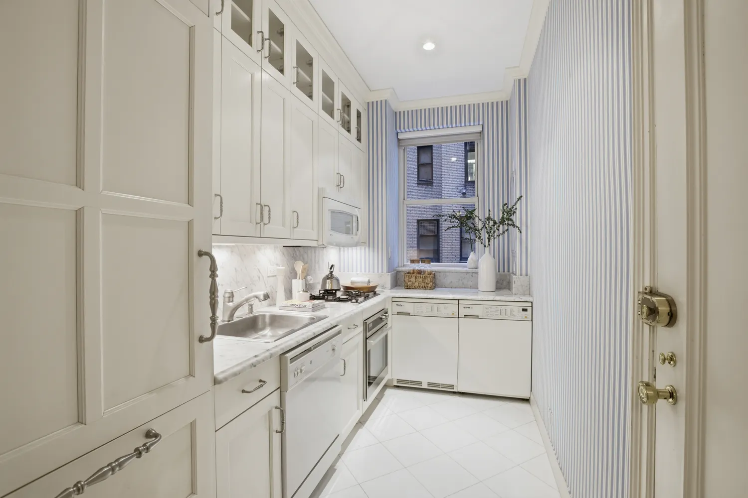 a kitchen with white cabinets and appliances