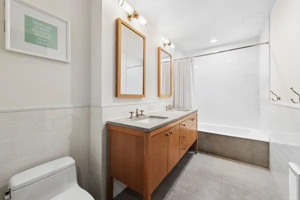 a bathroom with a granite countertop sink a toilet and a mirror
