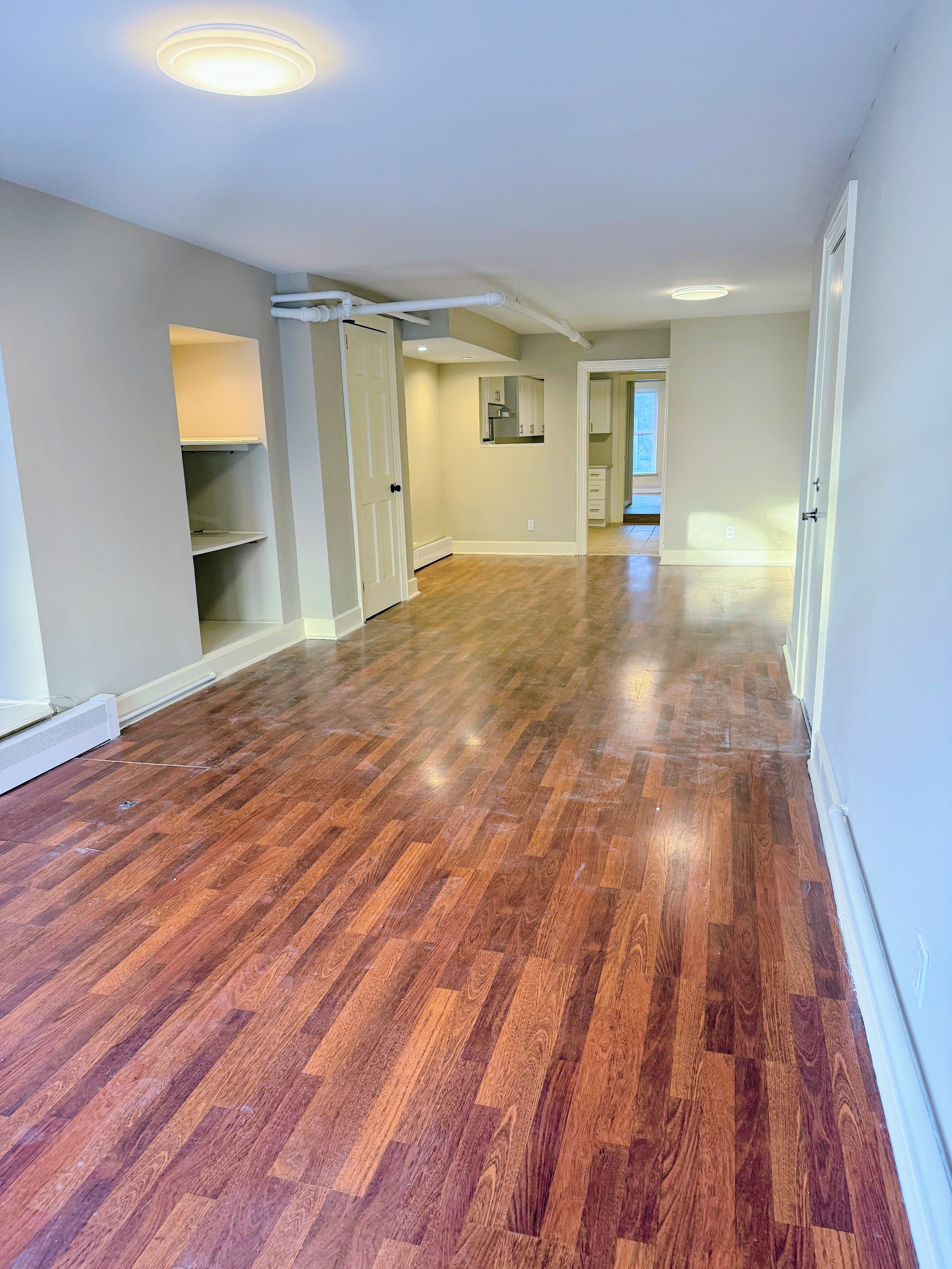 642 West 207th Street, Unit 1 Manhattan, NY 10034 - Photo 3 of 11 a view of empty room with wooden floor and fan