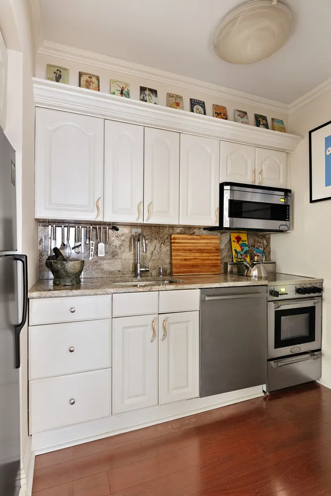 a kitchen with granite countertop white cabinets and stainless steel appliances