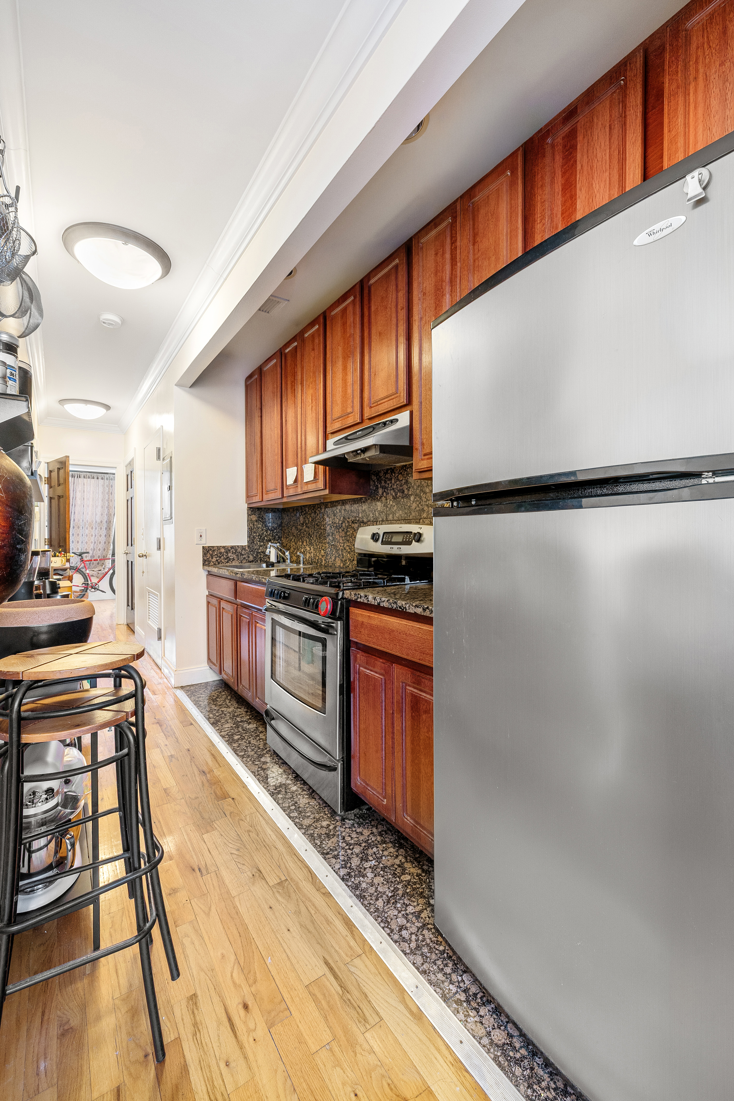518 West 149th Street Manhattan, NY 10031 - Photo 16 of 23 a kitchen with granite countertop a refrigerator a stove a sink and a counter space