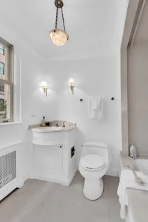 a bathroom with a toilet a sink and mirror