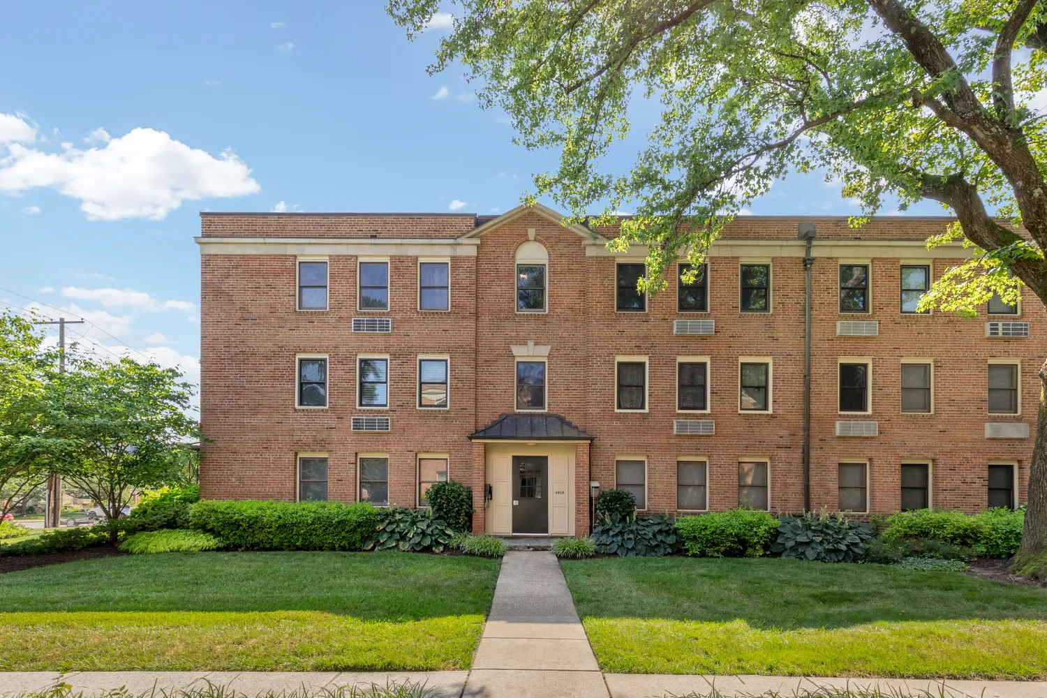a front view of a brick house with a yard