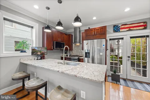 a kitchen with stainless steel appliances granite countertop a sink a stove and a refrigerator