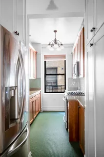 a kitchen with granite countertop a refrigerator and a stove top oven