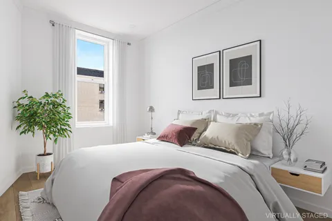 a bedroom with a bed and a potted plant