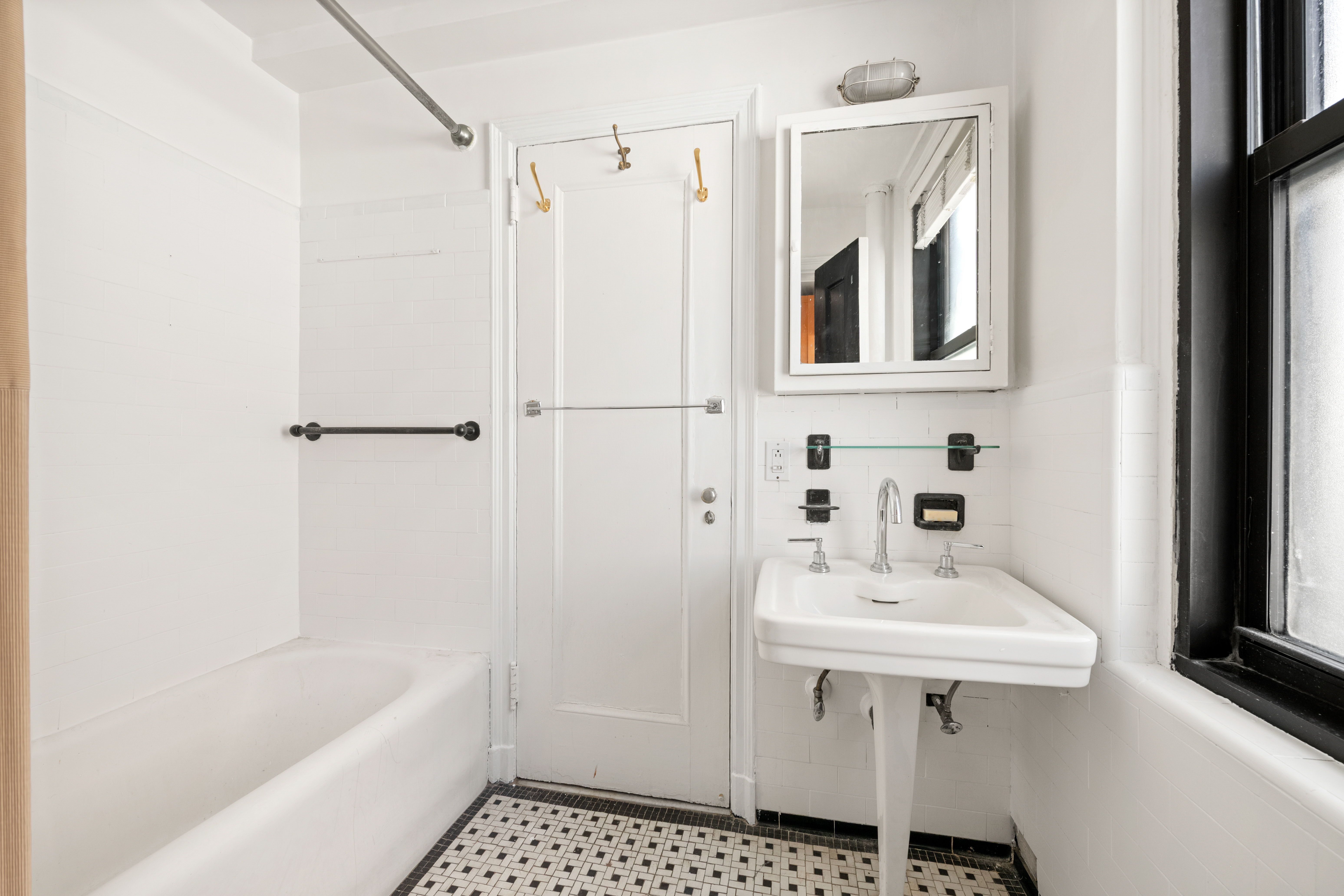 210 East 73rd Street, Unit 9EF Manhattan, NY 10021 - Photo 10 of 16 a bathroom with a sink a mirror and a bathtub