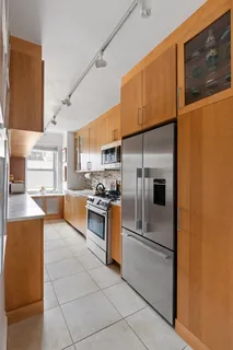 a kitchen with stainless steel appliances granite countertop a refrigerator a stove and a sink with wooden floor