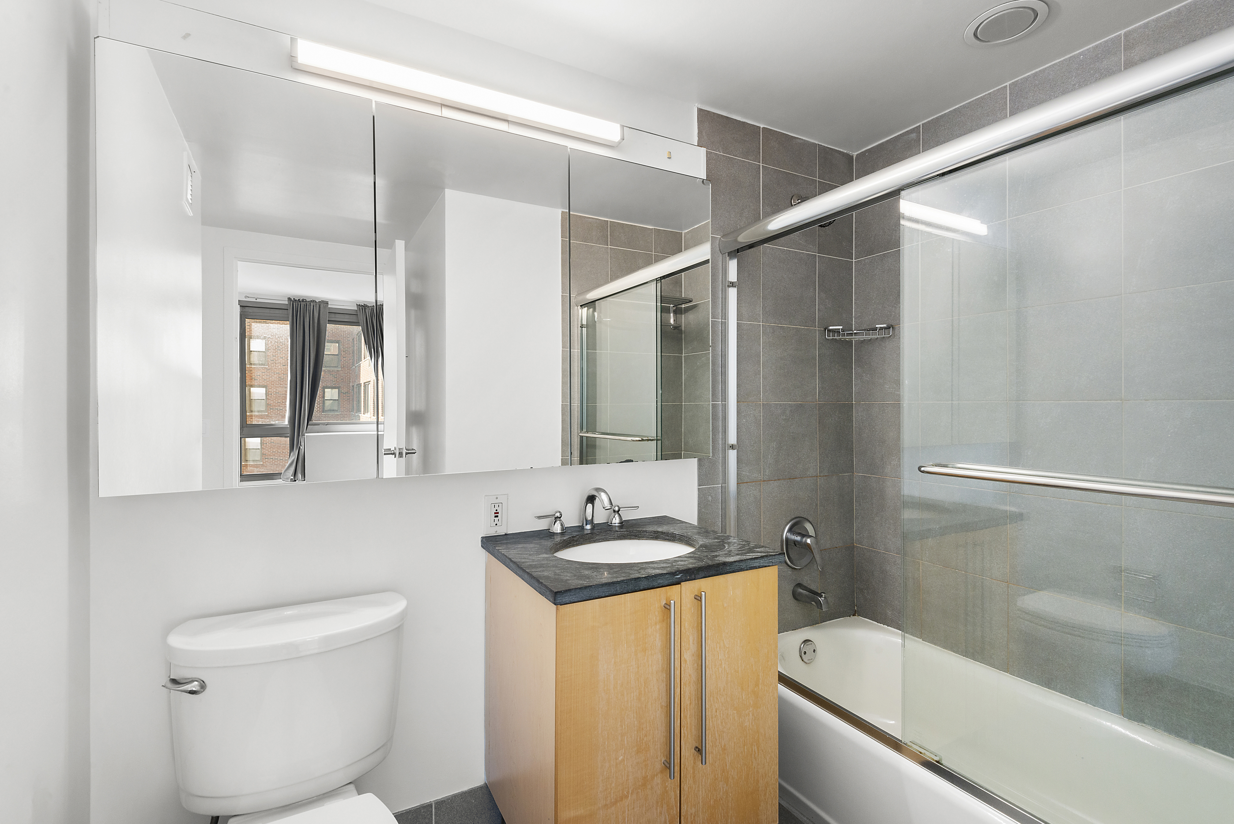 242 East 25th Street, Unit 9A Manhattan, NY 10010 - Photo 15 of 18 a bathroom with a granite countertop sink toilet and shower