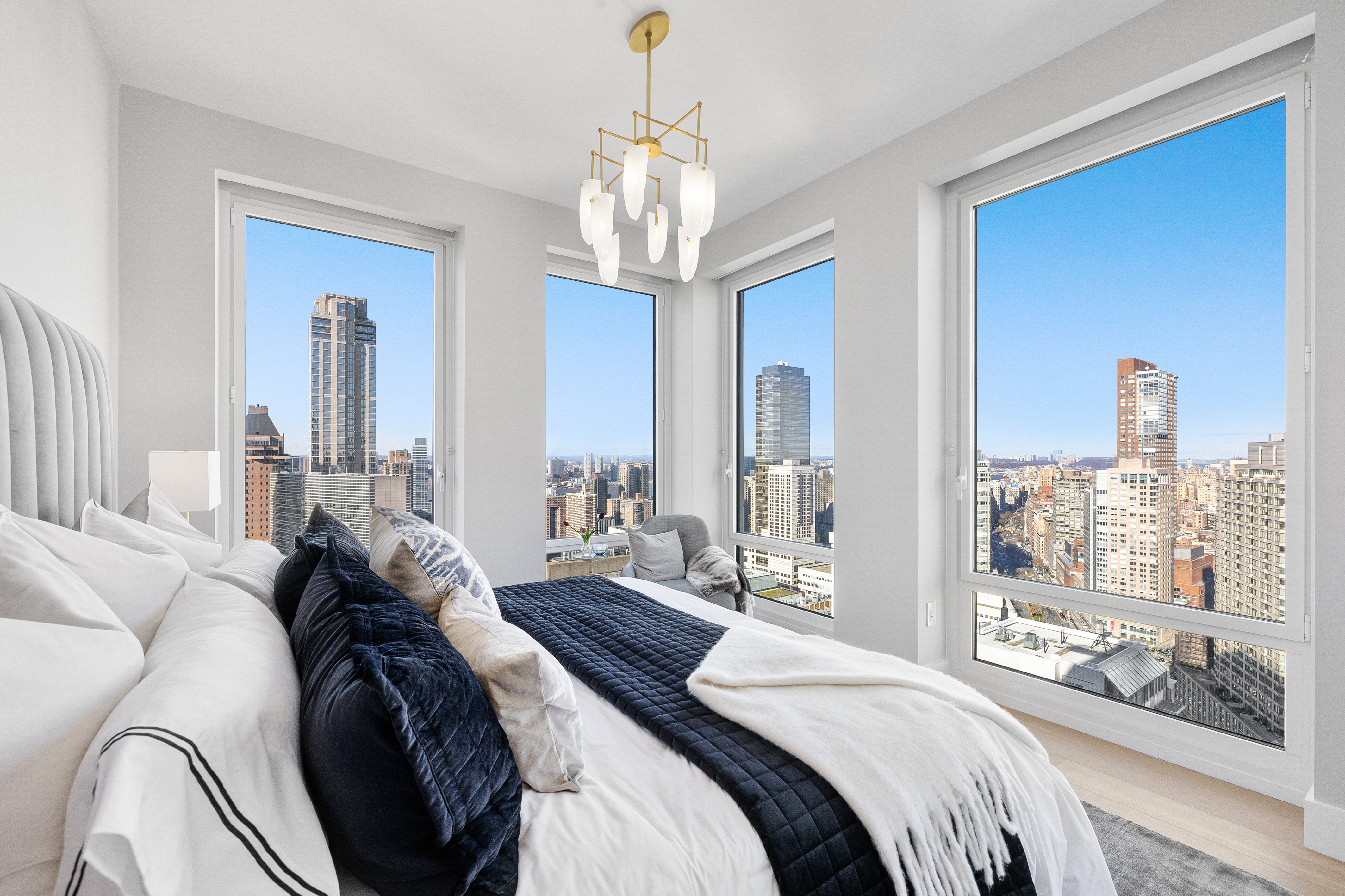 15 West 61st Street, Unit PH1C Manhattan, NY 10023 - Photo 15 of 26 a bedroom with a large bed and a chandelier