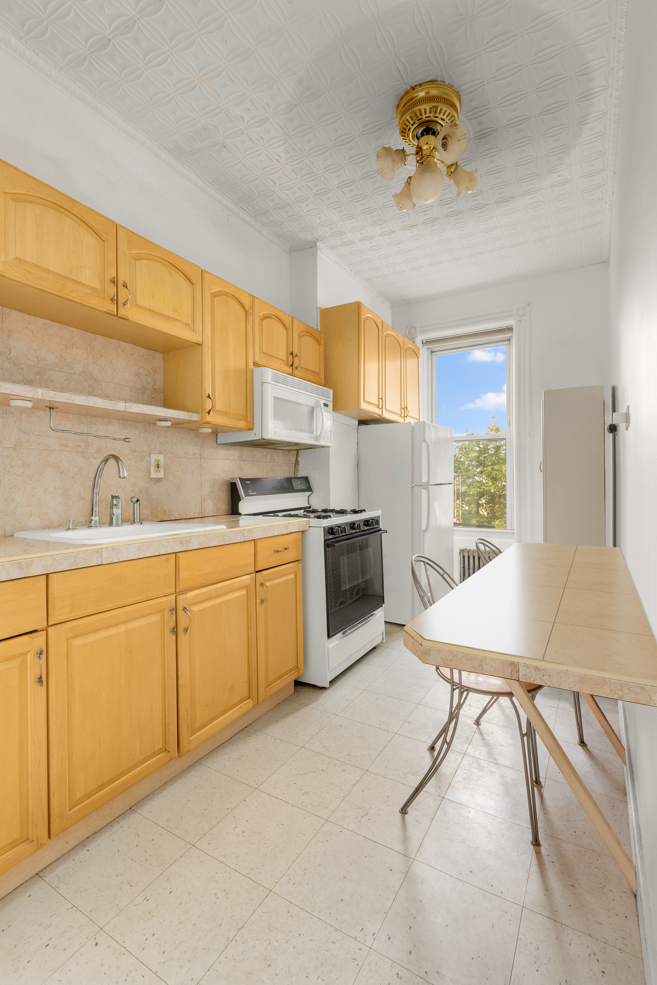 449 11th Street Brooklyn, NY 11215 - Photo 5 of 17 a kitchen with a stove a sink cabinets and a window