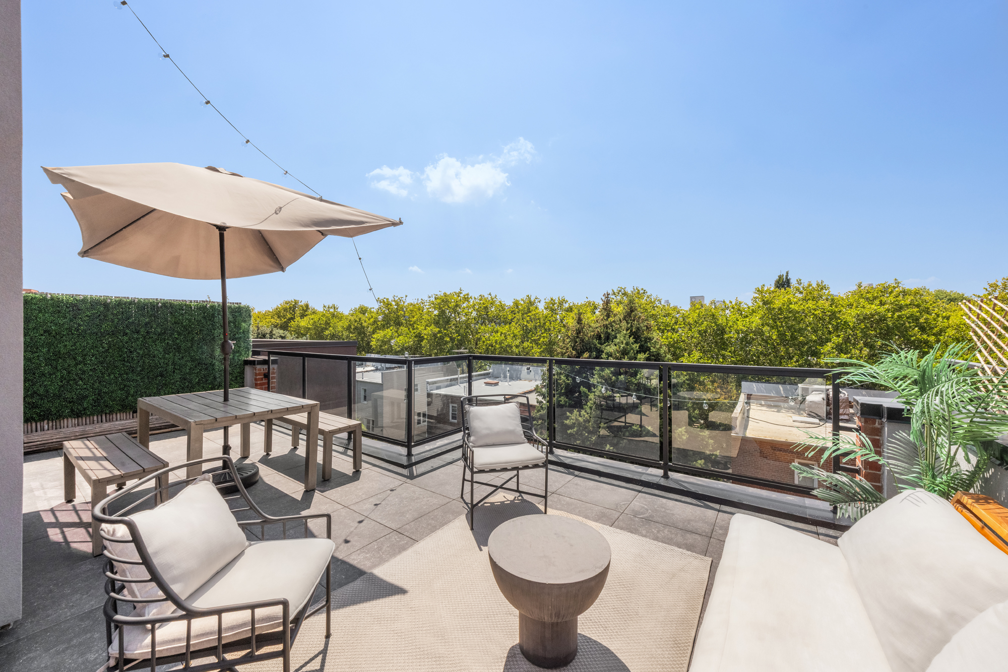 43 Newel Street, Unit PH2 Brooklyn, NY 11222 - Photo 8 of 10 a view of a patio with couches table and chairs under an umbrella