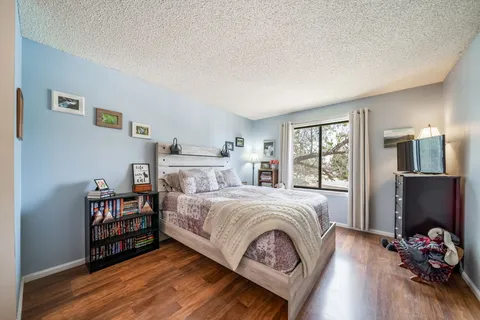 a bedroom with a bed and wooden floor