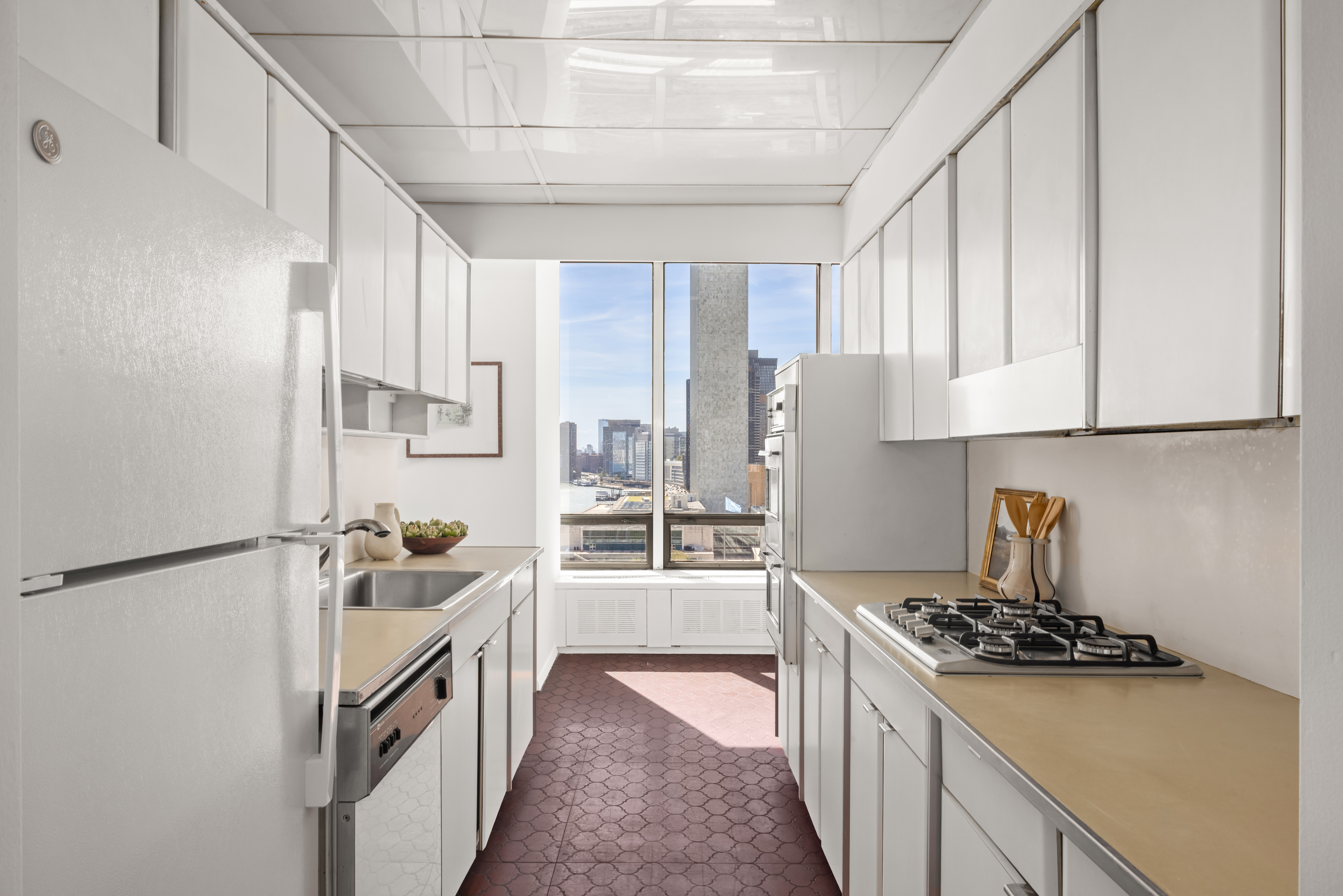870 United Nations Plaza, Unit 14F Manhattan, NY 10017 - Photo 5 of 16 a kitchen with sink a stove and refrigerator