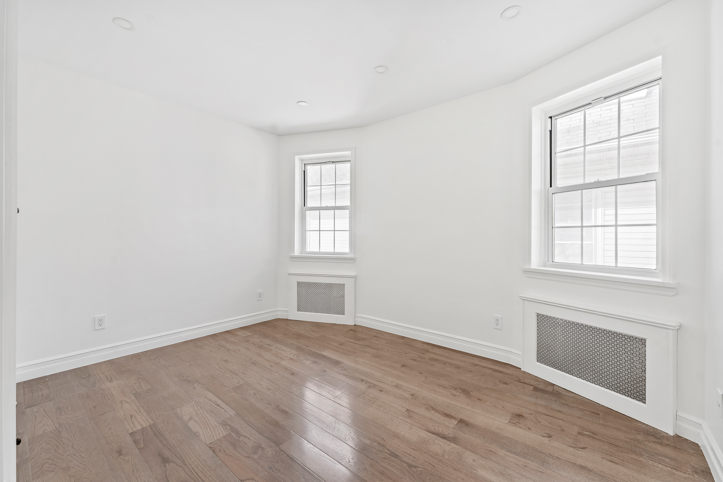 65 Bay 23rd Street, Unit 2 Brooklyn, NY 11214 - Photo 7 of 16 an empty room with wooden floor and windows