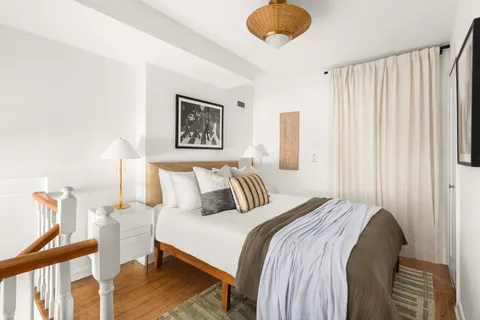 a bedroom with a bed and a painting on the wall