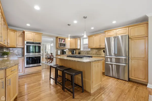 a kitchen with stainless steel appliances granite countertop a refrigerator and a stove top oven