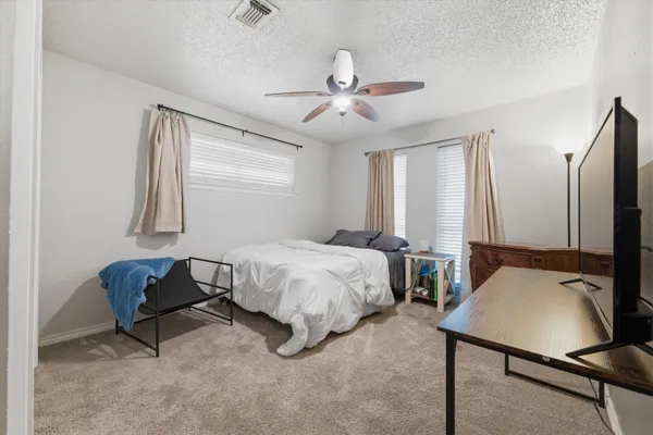a spacious bedroom with a bed window and couch